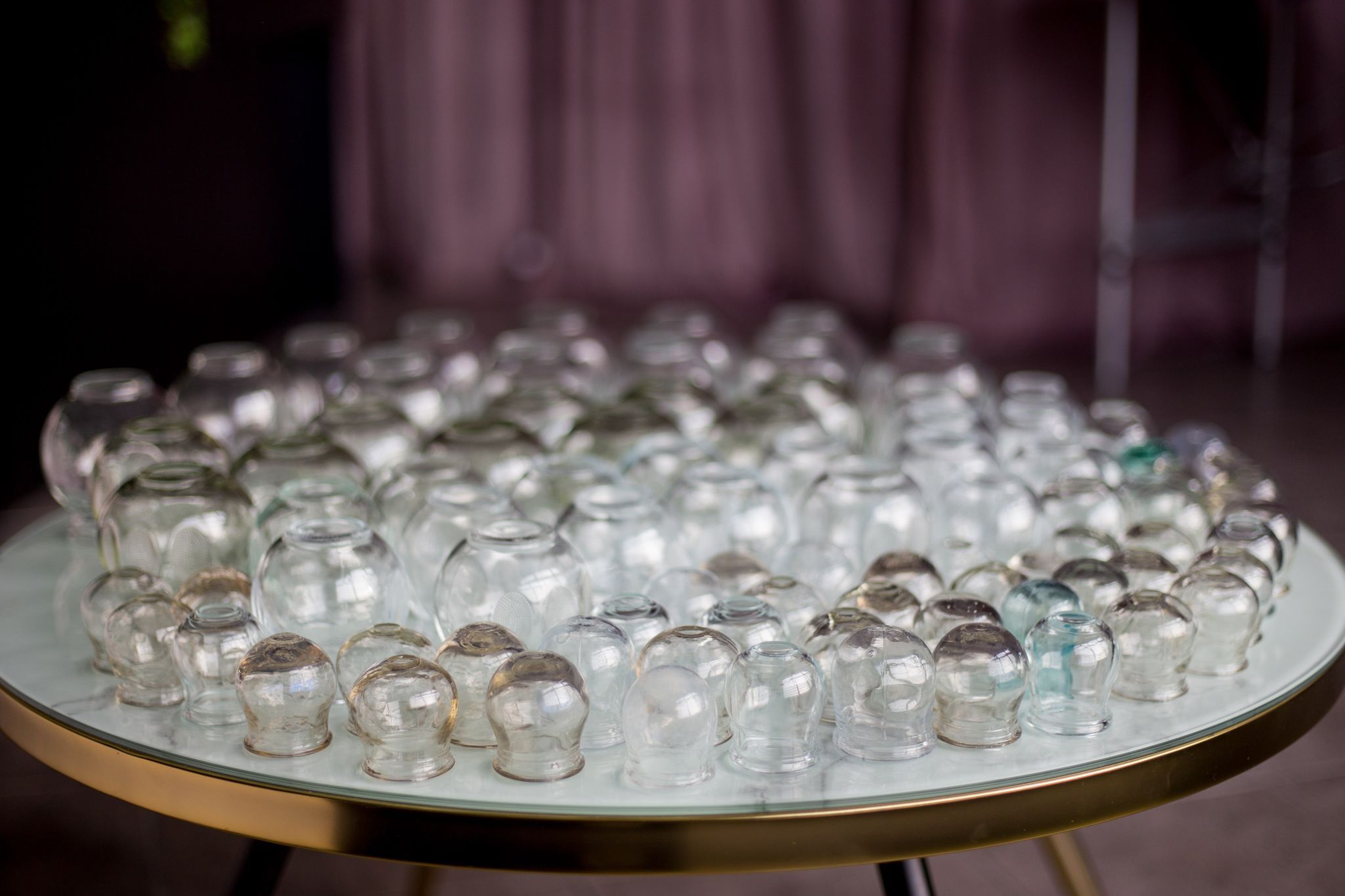 Tradycyjne szklane bańki na okrągłej tacy w gabinecie bańkoterapii w Lubinie